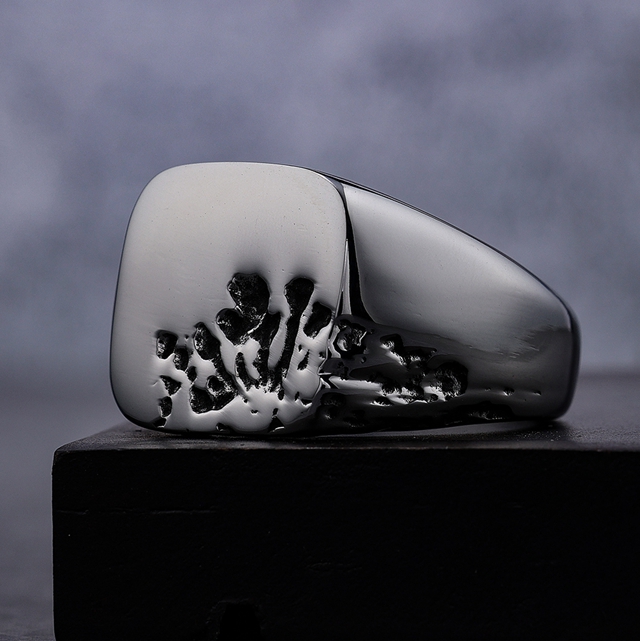 Side detail of stainless steel signet ring showing black recessed distressed marks